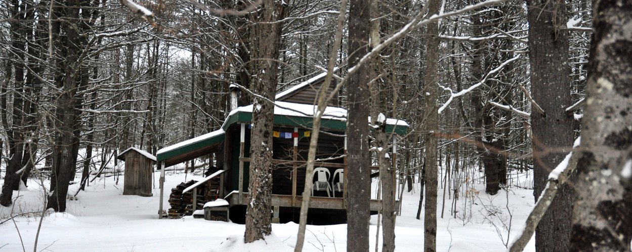 Solitary retreat cabin in a snowy Vermont forest